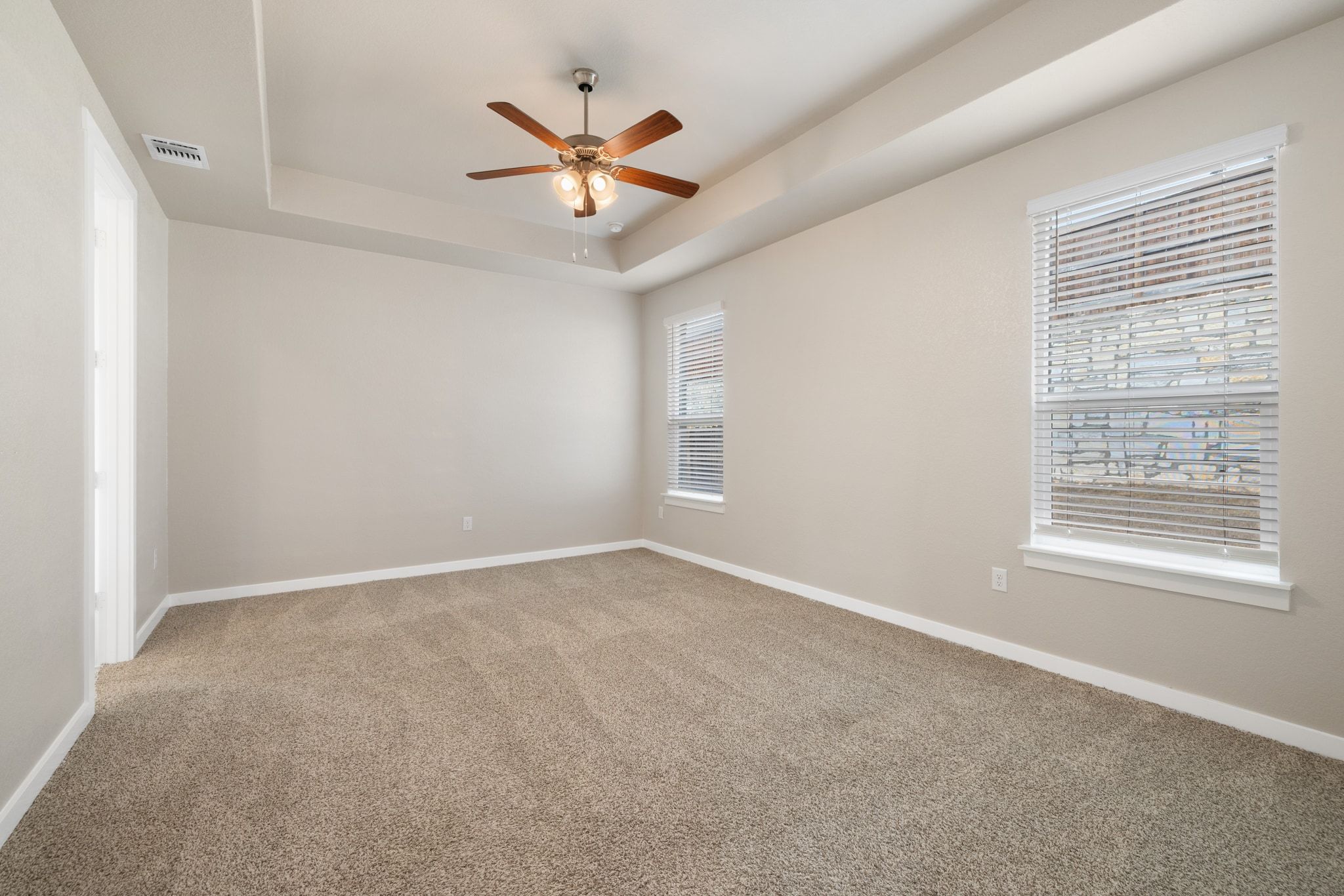 309 Barton Run Drive Georgetown, TX 78628 - Photo 13 of 35 Spare room featuring light colored carpet, a tray ceiling, and a ceiling fan