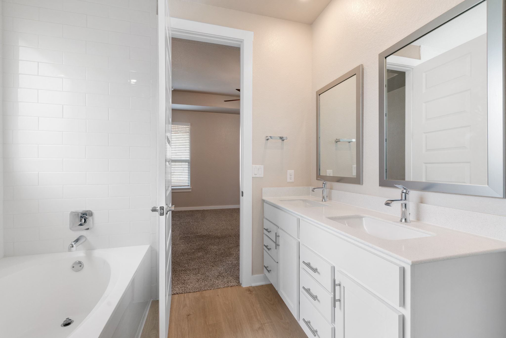 309 Barton Run Drive Georgetown, TX 78628 - Photo 14 of 35 Full bath with double vanity, light wood-style flooring, a bath, and light colored carpet