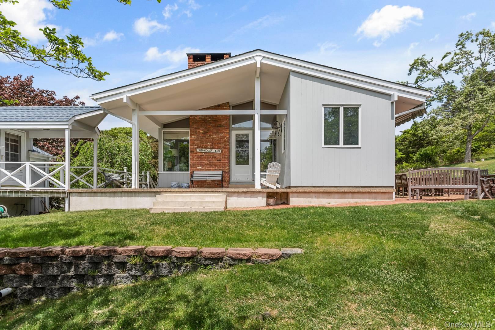 16 South Beach Road Southampton, NY 11968 - Photo 2 of 14 Back of house featuring a yard and a sunroom