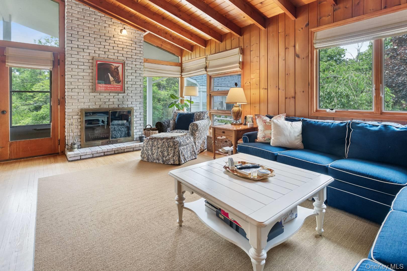 16 South Beach Road Southampton, NY 11968 - Photo 7 of 14 Living area with healthy amount of natural light, wood ceiling, a fireplace, wood walls, and wood finished floors