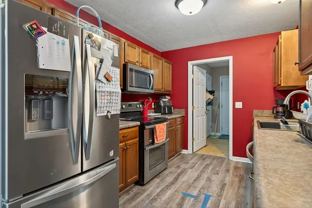 a kitchen with stainless steel appliances granite countertop a refrigerator and a stove