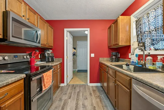 a kitchen with stainless steel appliances granite countertop a stove a sink and a microwave