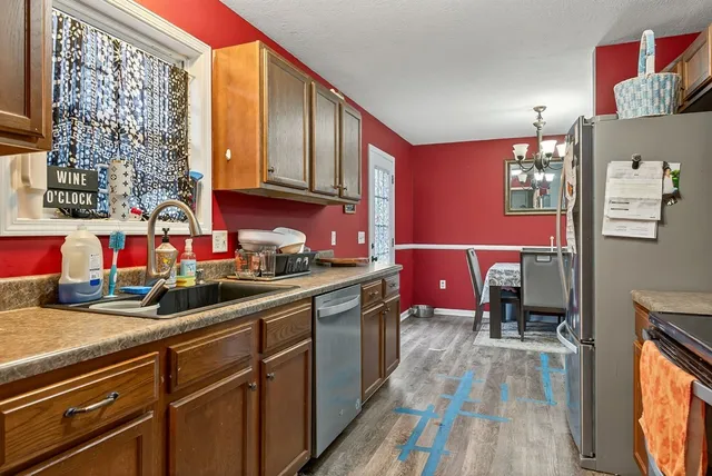 a kitchen with stainless steel appliances granite countertop a stove a sink dishwasher and cabinets with wooden floor