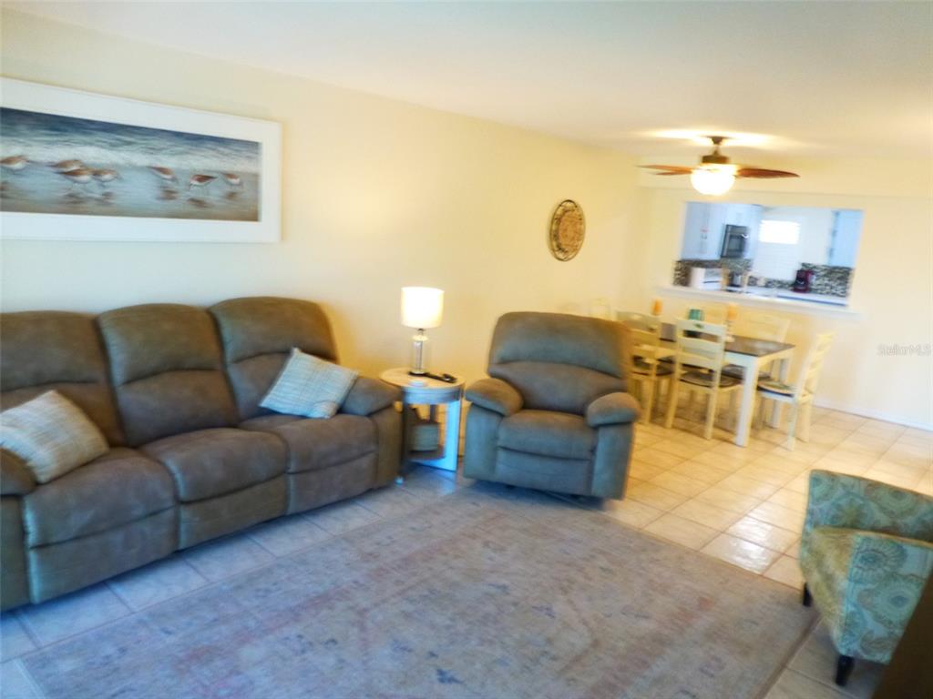 5557 Sea Forest Drive, Unit 215 New Port Richey, FL 34652 - Photo 12 of 40 a living room with furniture and a table