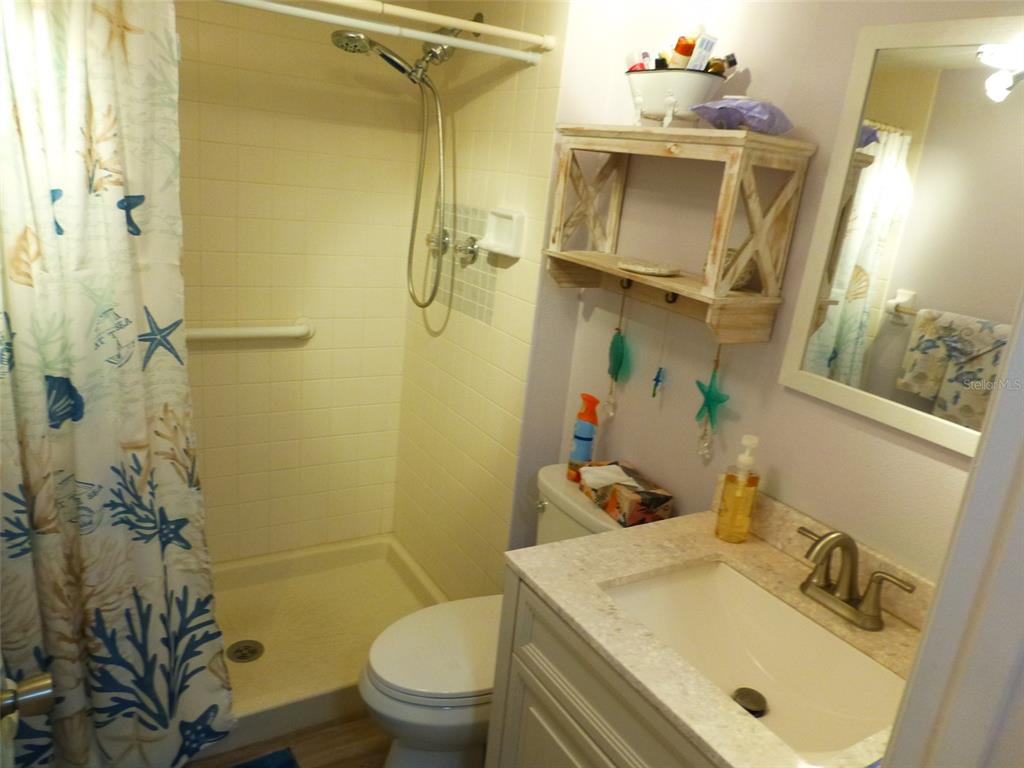 5557 Sea Forest Drive, Unit 215 New Port Richey, FL 34652 - Photo 15 of 40 a bathroom with a sink toilet and shower
