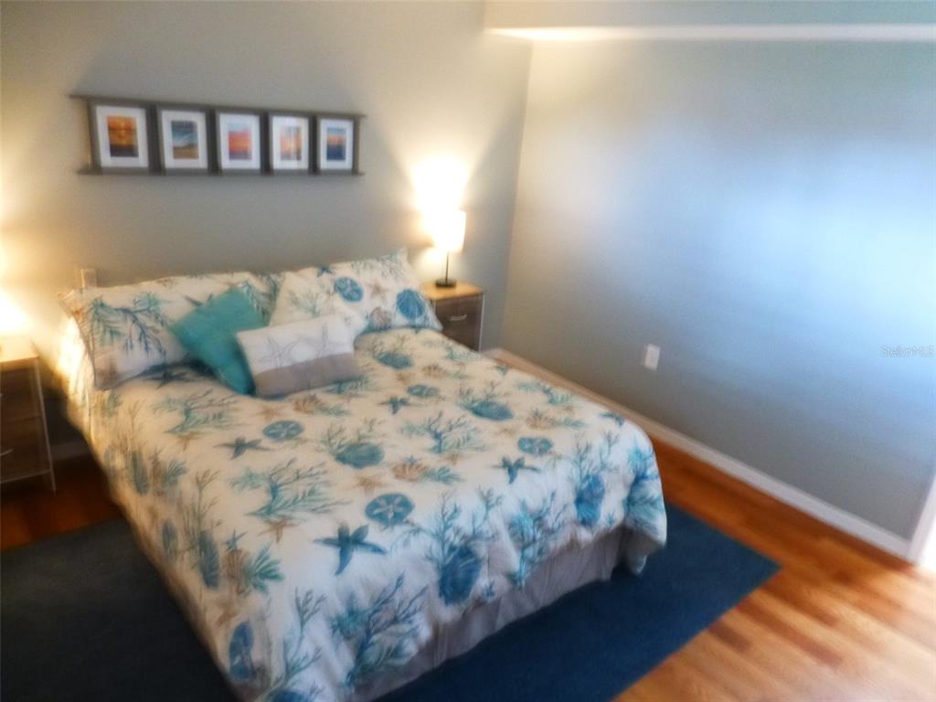 5557 Sea Forest Drive, Unit 215 New Port Richey, FL 34652 - Photo 16 of 40 a bed sitting in a bedroom next to a window