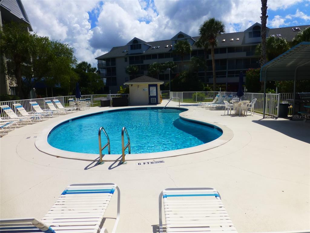 5557 Sea Forest Drive, Unit 215 New Port Richey, FL 34652 - Photo 30 of 40 a view of a swimming pool with a patio