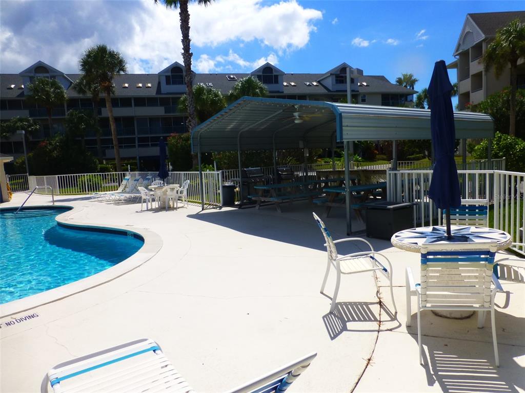 5557 Sea Forest Drive, Unit 215 New Port Richey, FL 34652 - Photo 31 of 40 a view of a patio with couches chairs and a fire pit