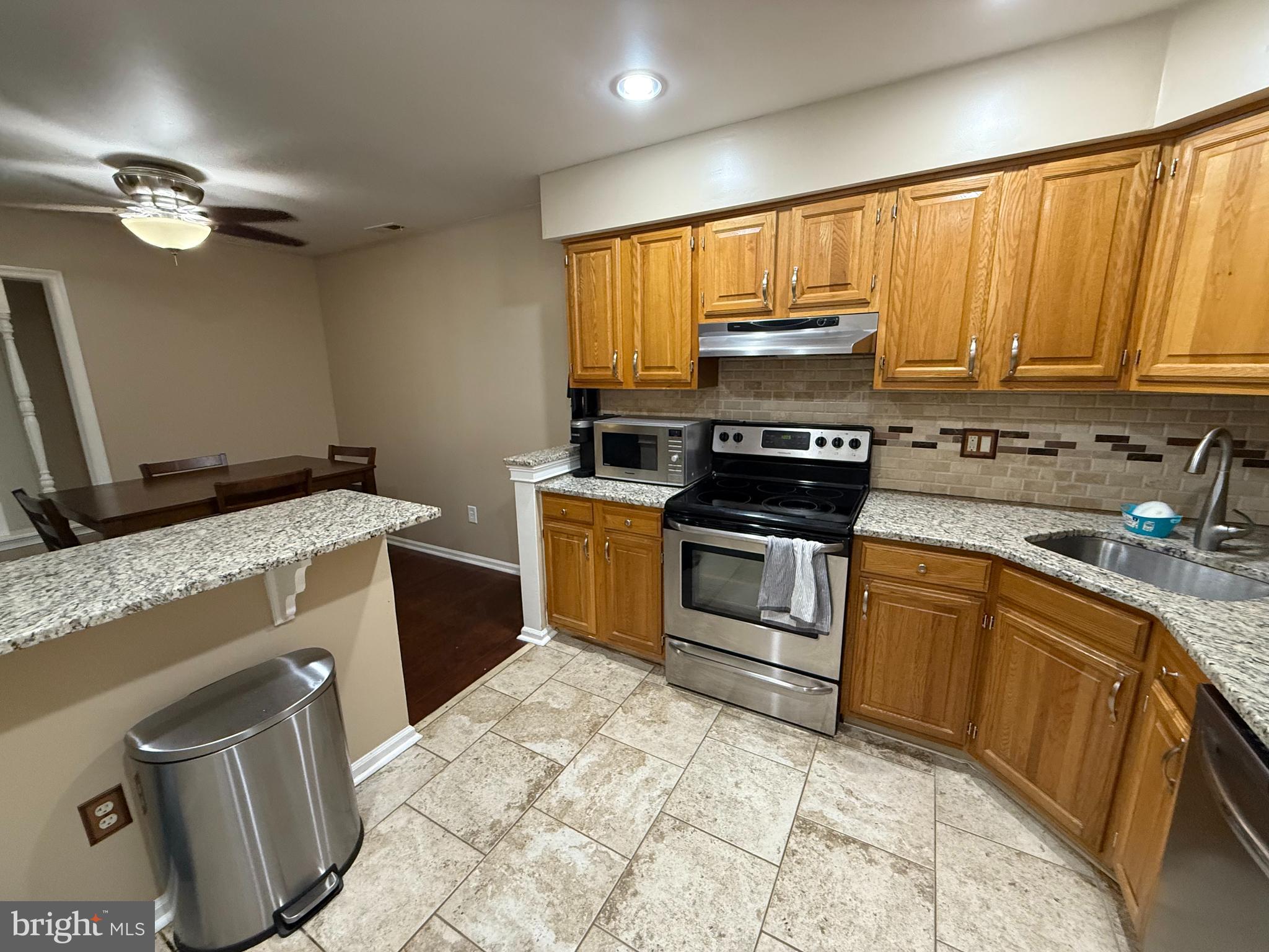 27 Pickwick Place Sewell, NJ 08080 - Photo 10 of 18 a kitchen with granite countertop a stove sink and cabinets