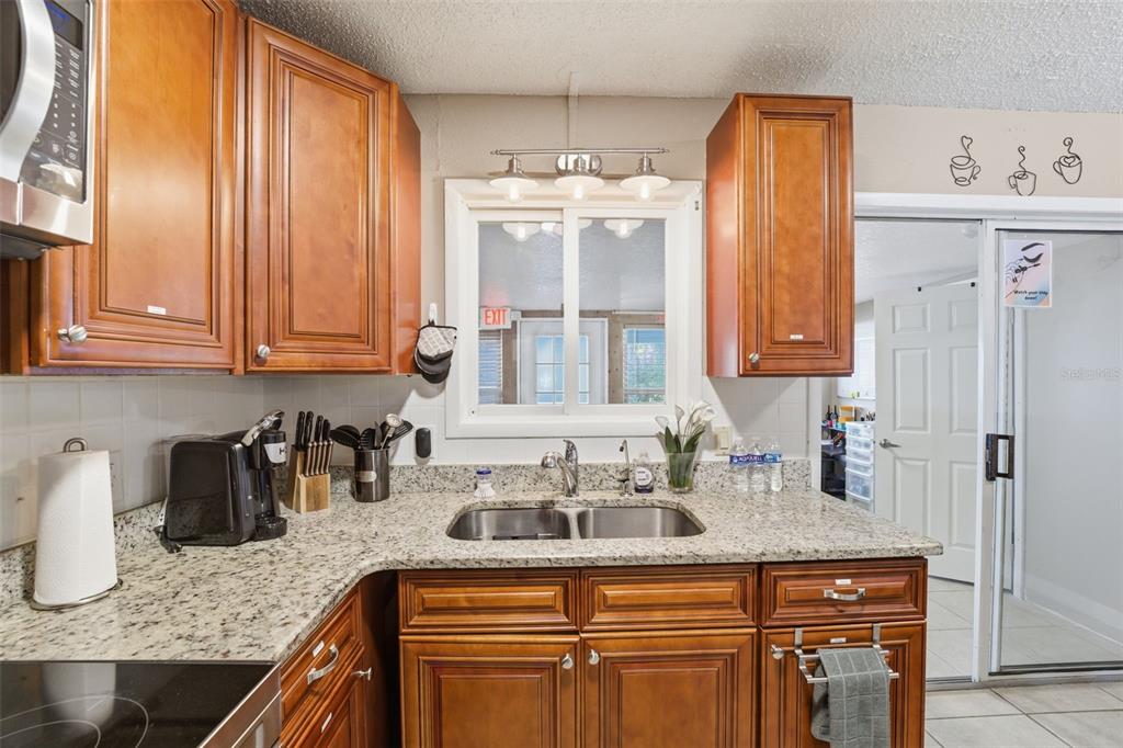 3290 Seaview Drive Spring Hill, FL 34606 - Photo 13 of 31 a kitchen with stainless steel appliances granite countertop a sink dishwasher and cabinets with wooden floor