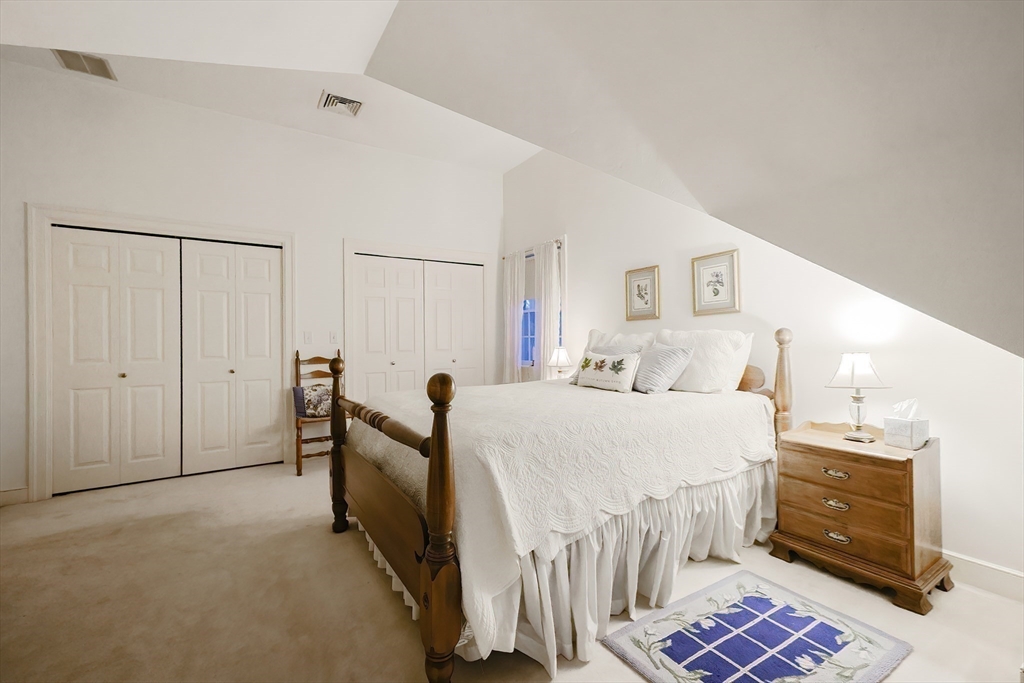 12 Highcroft Way, Unit 12 Hopkinton, MA 01748 - Photo 19 of 37 a spacious bedroom with a bed and a cabinets