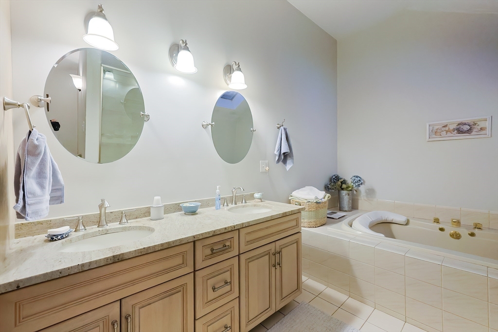 12 Highcroft Way, Unit 12 Hopkinton, MA 01748 - Photo 26 of 37 a bathroom with a double vanity sink and a mirror