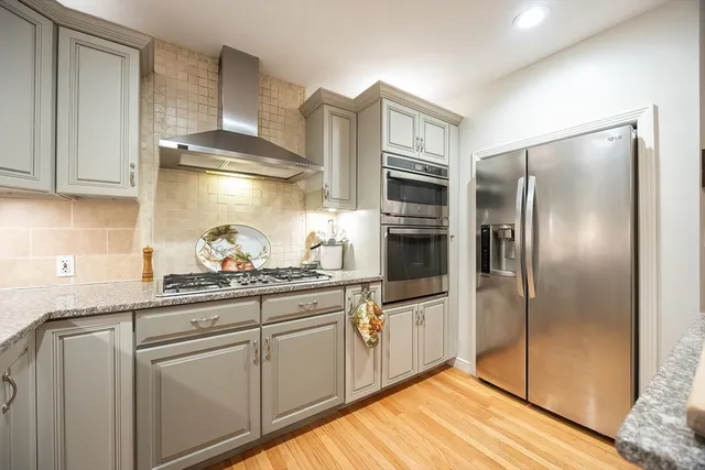 a kitchen with stainless steel appliances granite countertop a refrigerator and a sink