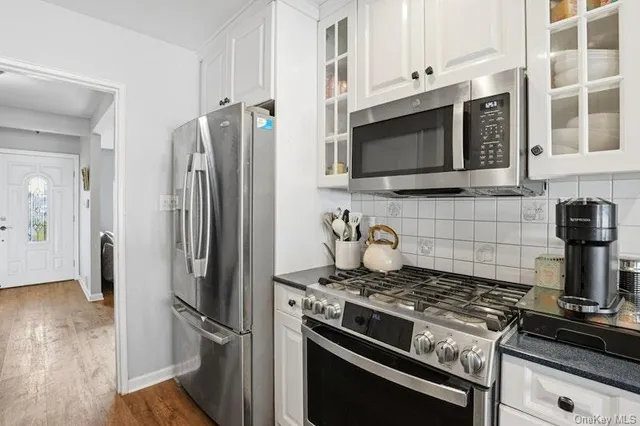 a kitchen with stainless steel appliances and wooden floor