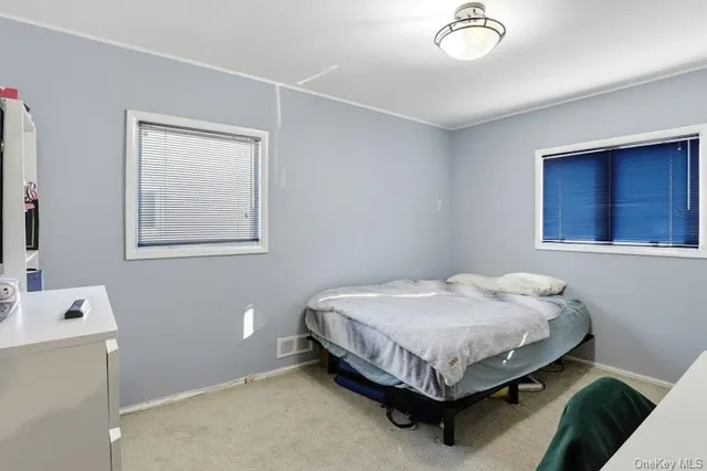 a bed sitting in a bedroom next to a window