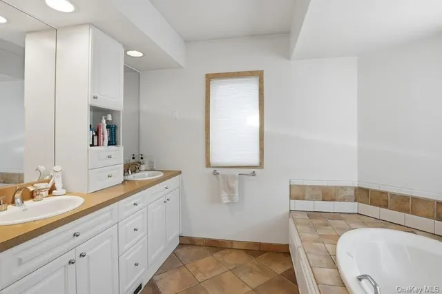 a en suite bathroom with a granite countertop sink and a mirror