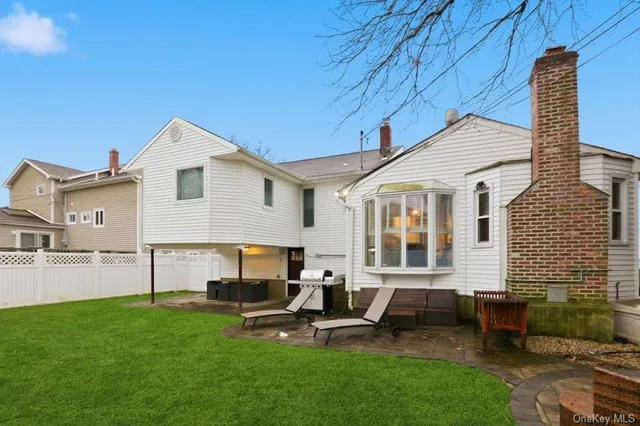 a view of a house with a backyard and chairs