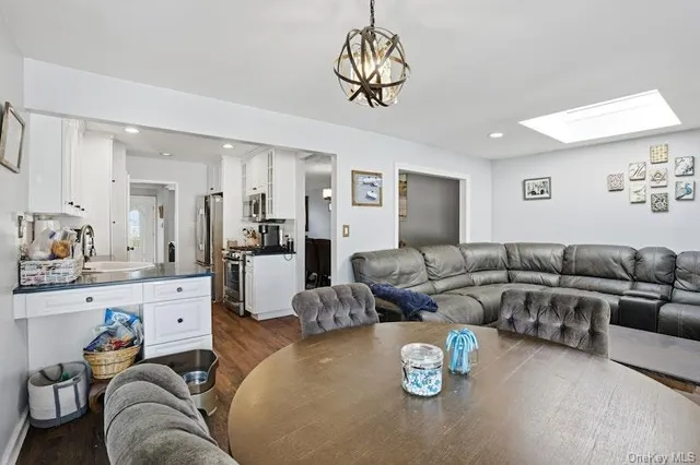 a living room with furniture kitchen and a chandelier