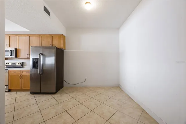 a view of a refrigerator in kitchen and a window