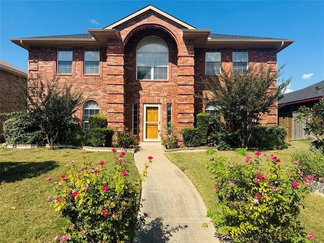 a front view of a house with a yard and flowers