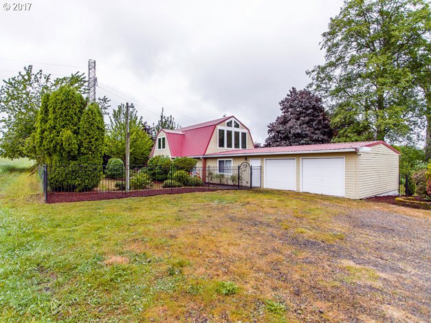 a front view of house with yard and trees in the background