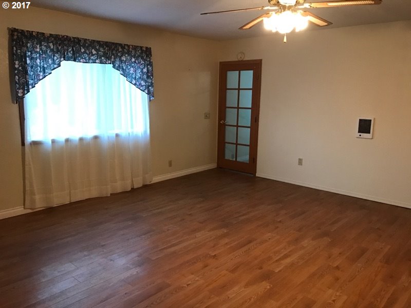 19495 Southeast Chambers Road Sandy, OR 97055 - Photo 21 of 32 an empty room with wooden floor chandelier and windows