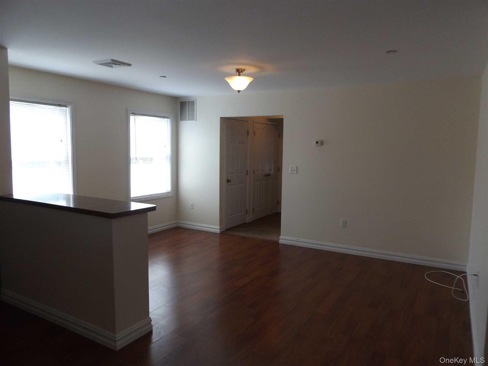 4 State Street, Unit 1 Beacon, NY 12508 - Photo 8 of 17 an empty room with wooden floor and windows