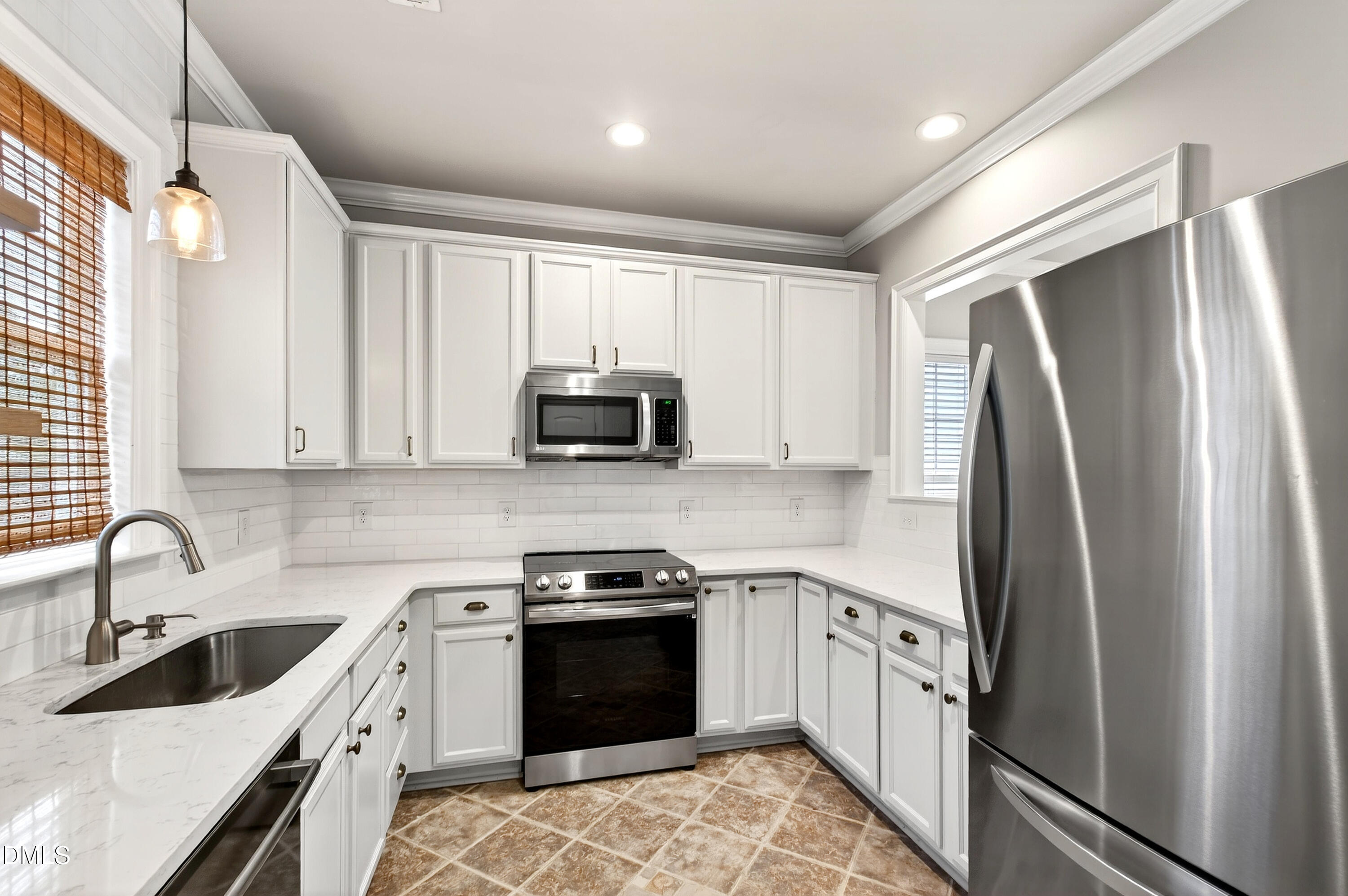 7756 ACC Boulevard Raleigh, NC 27617 - Photo 15 of 40 a kitchen with white cabinets and stainless steel appliances