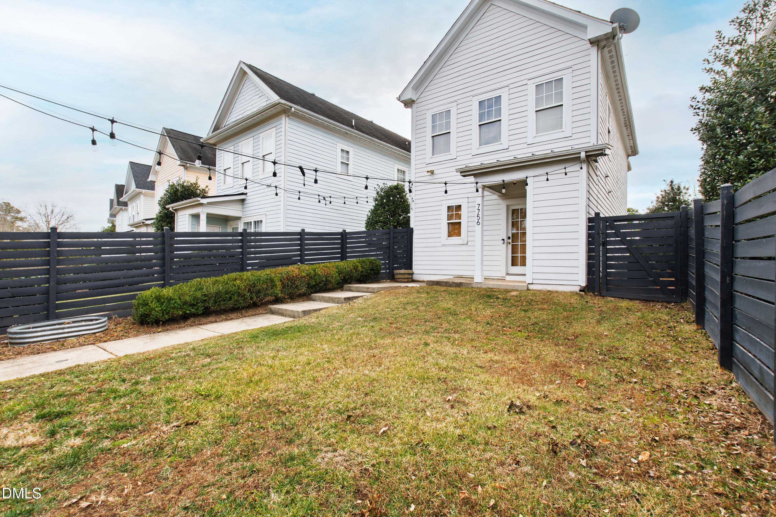 7756 ACC Boulevard Raleigh, NC 27617 - Photo 36 of 40 a view of a white house with a large pool and wooden fence