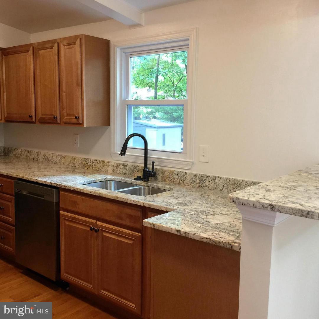 2312 Whitetail Court Reston, VA 20191 - Photo 6 of 26 a kitchen with granite countertop a sink a stove and cabinets