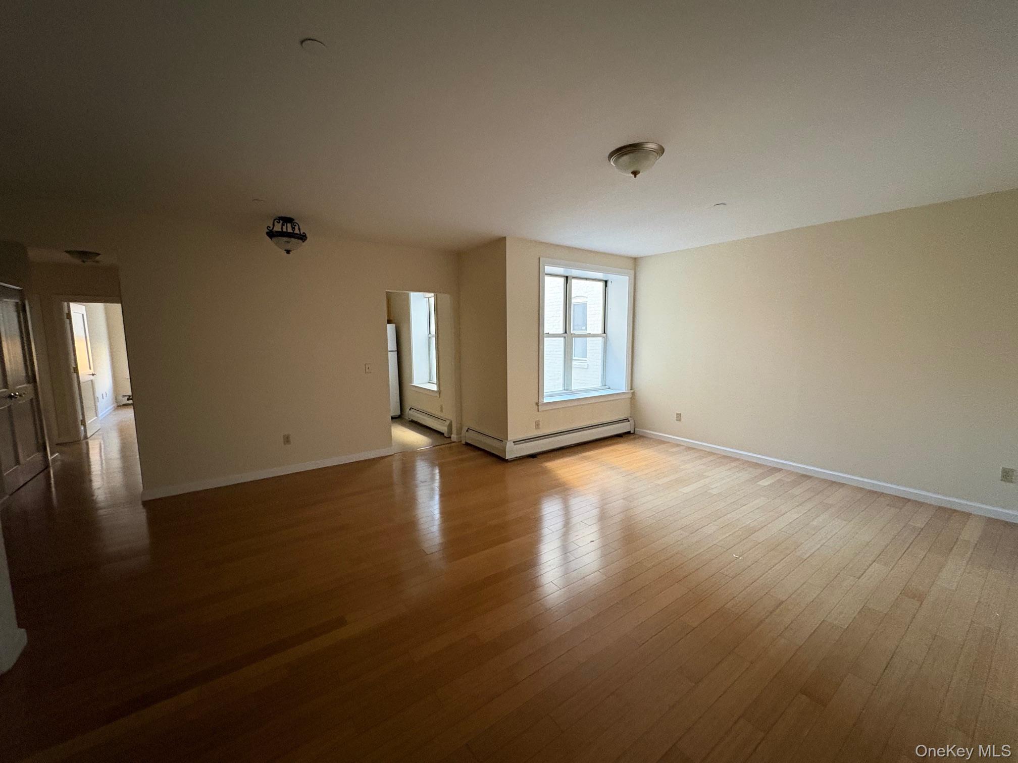 85 Bronx River Road, Unit 3S Yonkers, NY 10704 - Photo 11 of 27 Unfurnished room featuring hardwood / wood-style flooring and baseboard heating