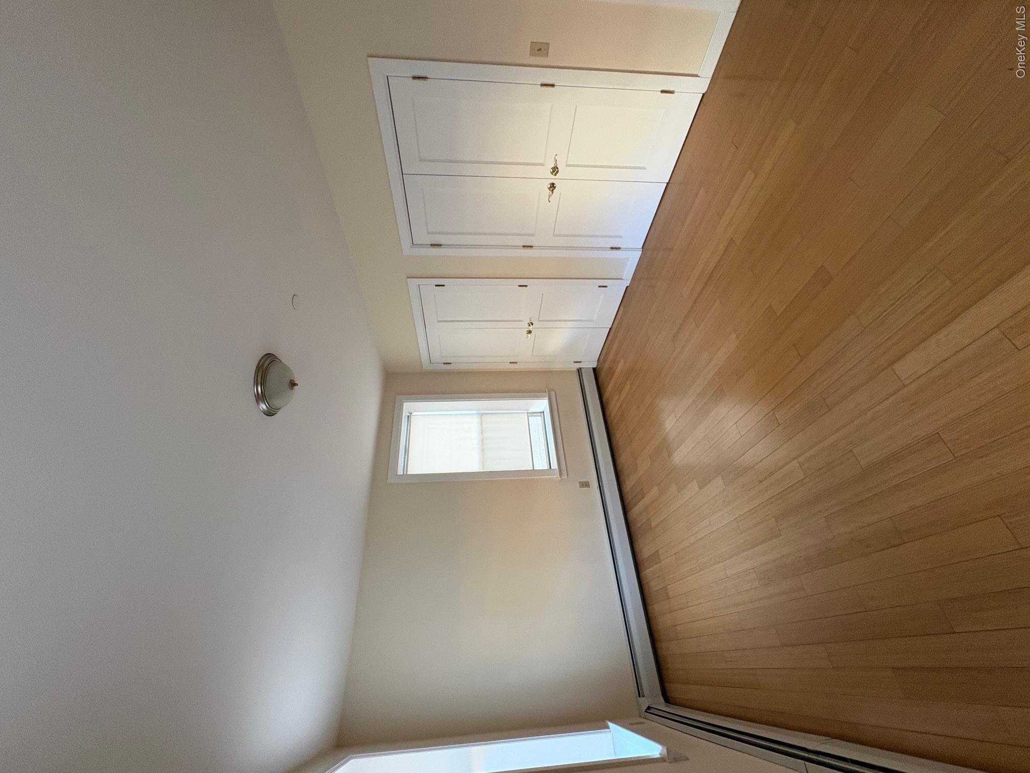 85 Bronx River Road, Unit 3S Yonkers, NY 10704 - Photo 15 of 27 Unfurnished bedroom featuring two closets, a baseboard heating unit, and light hardwood finished floors
