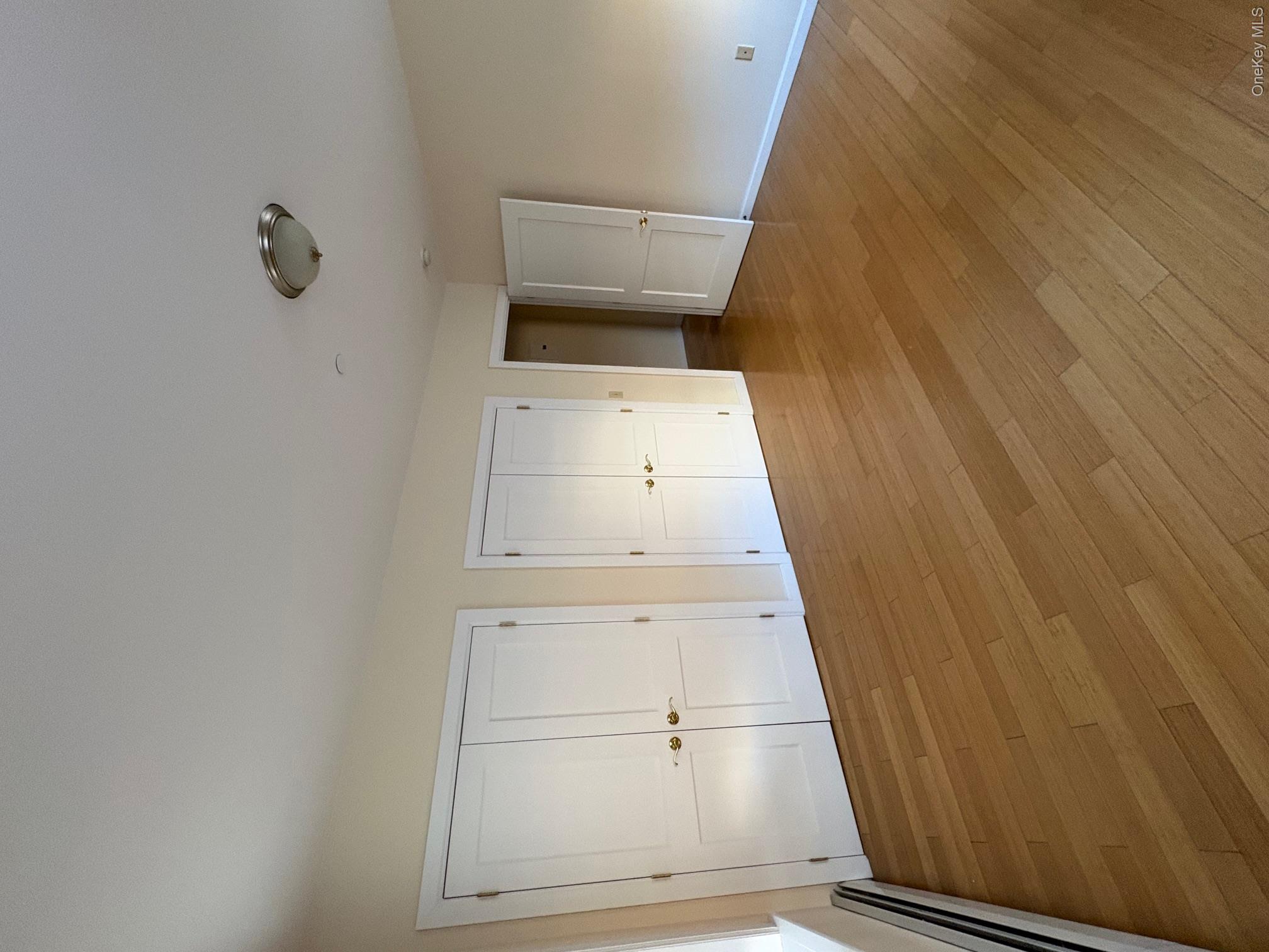 85 Bronx River Road, Unit 3S Yonkers, NY 10704 - Photo 16 of 27 Unfurnished bedroom with a baseboard heating unit, two closets, and hardwood / wood-style flooring