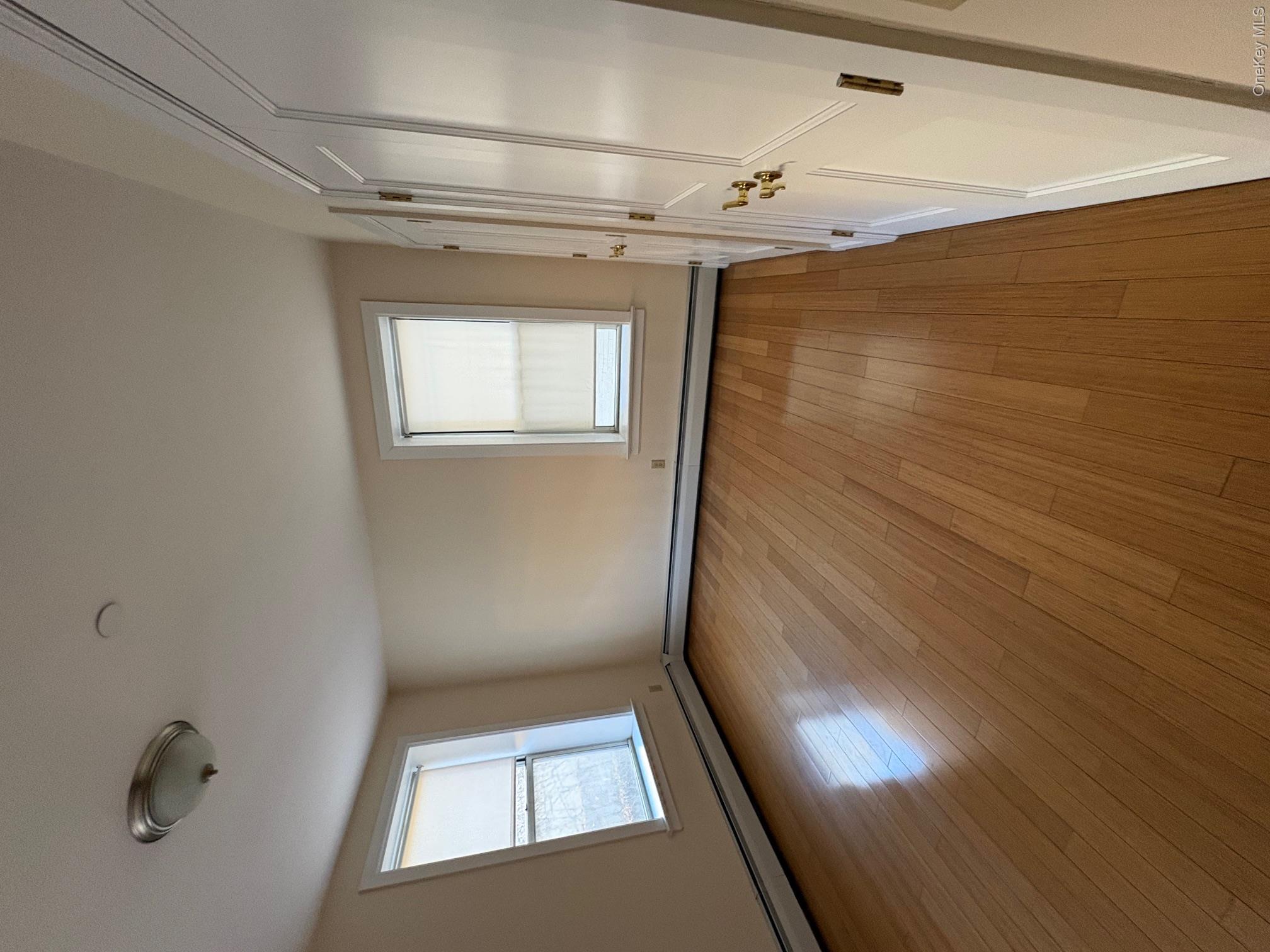 85 Bronx River Road, Unit 3S Yonkers, NY 10704 - Photo 17 of 27 Unfurnished bedroom with a baseboard heating unit, light hardwood flooring, and a dual closets