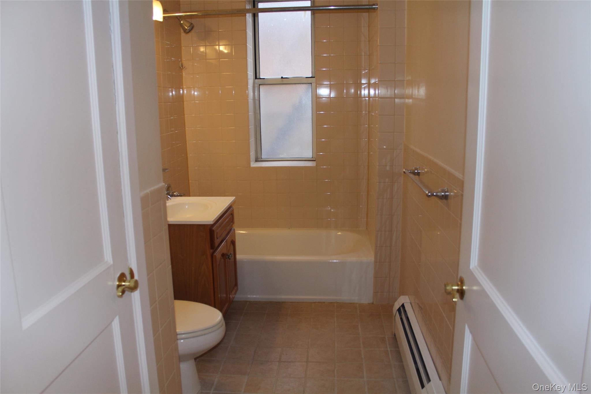85 Bronx River Road, Unit 3S Yonkers, NY 10704 - Photo 18 of 27 Bathroom with vanity, a baseboard radiator, light tile patterned flooring, and bathtub / shower combination