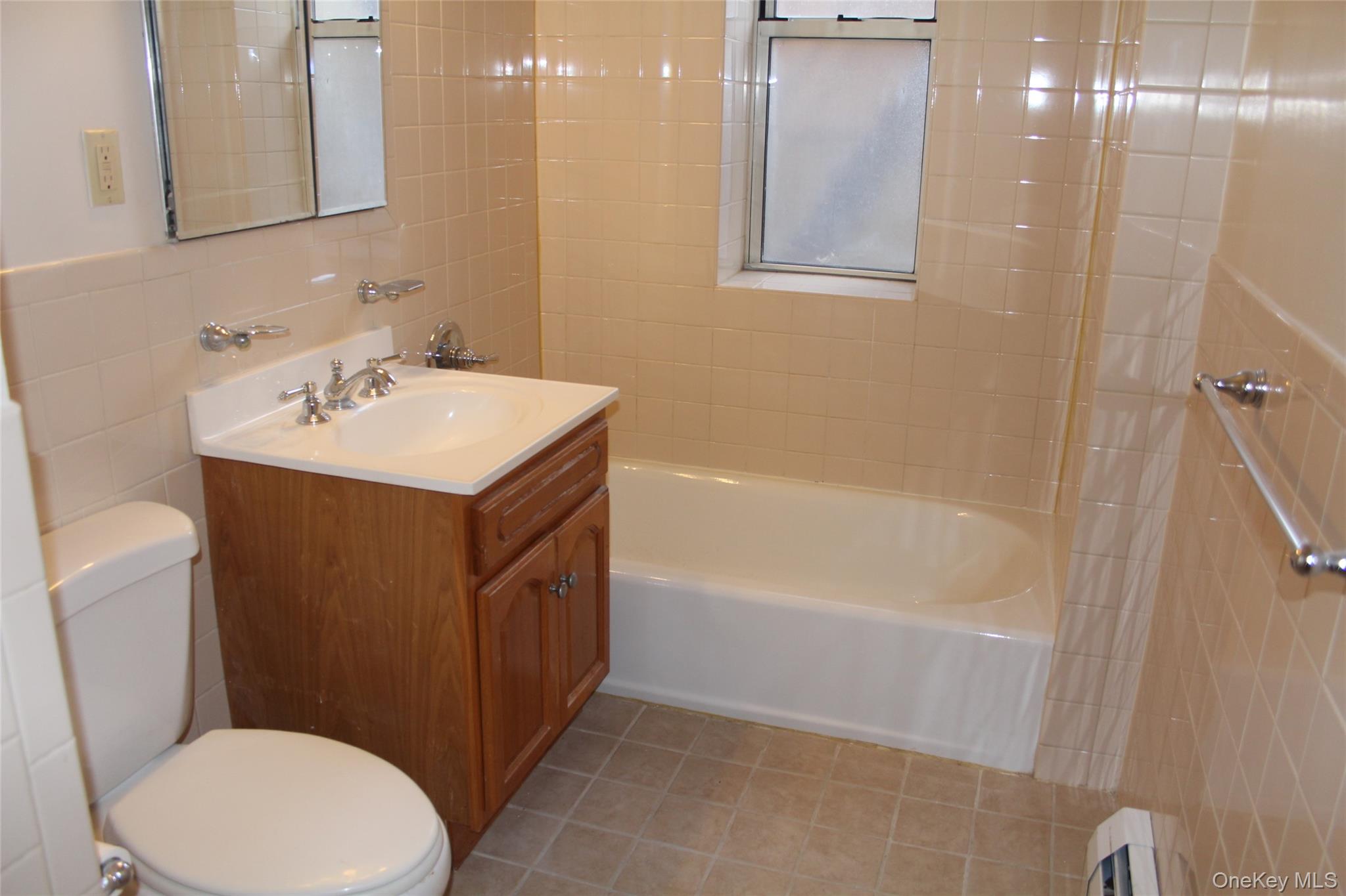 85 Bronx River Road, Unit 3S Yonkers, NY 10704 - Photo 20 of 27 Bathroom featuring tile walls, vanity, washtub / shower combination, and light tile patterned floors