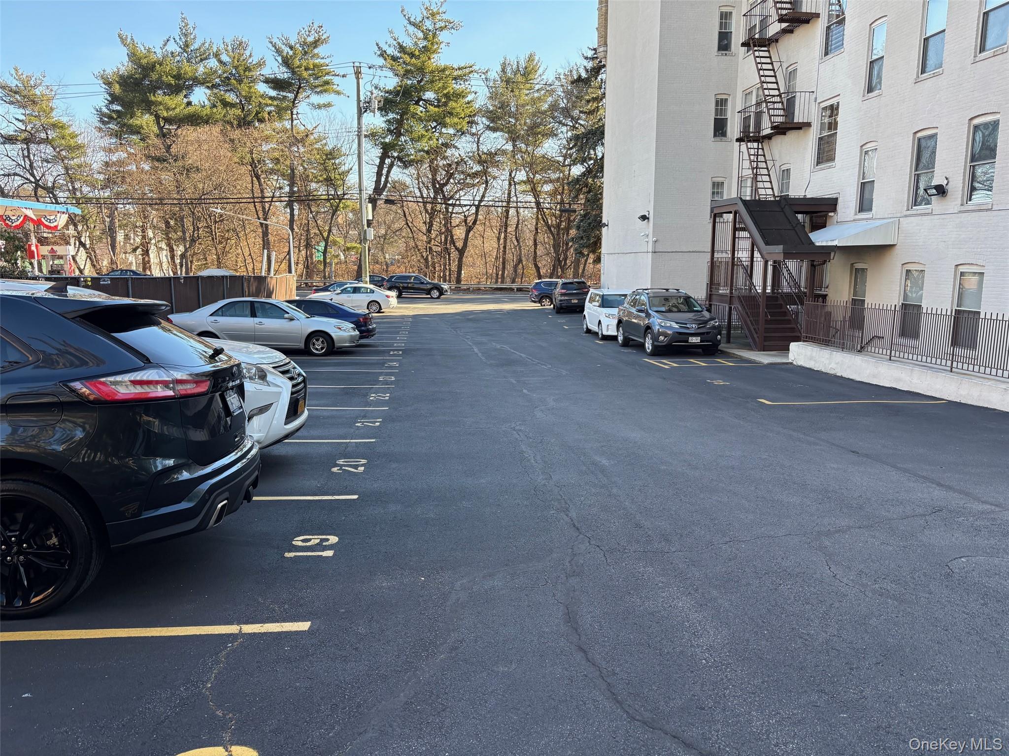 85 Bronx River Road, Unit 3S Yonkers, NY 10704 - Photo 21 of 27 Uncovered parking lot featuring stairs that lead to back entrance
