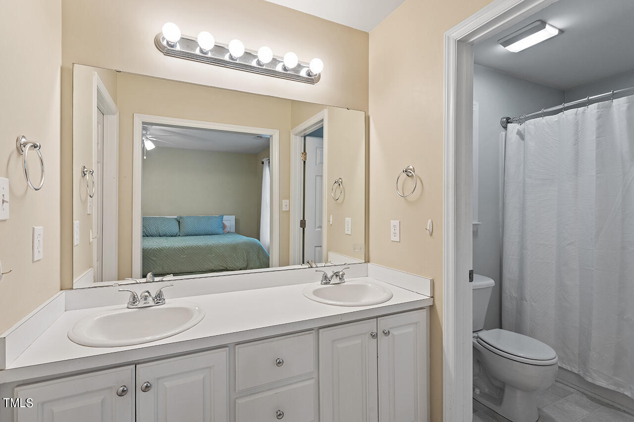 2001 Eagle View Drive Wendell, NC 27591 - Photo 23 of 33 a bathroom with double vanity sinks a toilet a mirror and shower