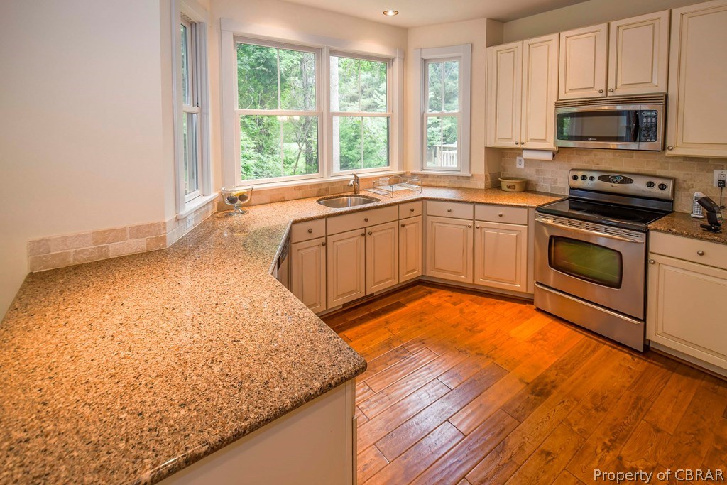 137 Mastons Wharf Road Lancaster, VA 22503 - Photo 14 of 39 a kitchen with stainless steel appliances granite countertop a stove a sink and a microwave