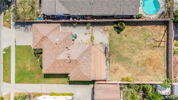 an aerial view of a house with a yard and large trees