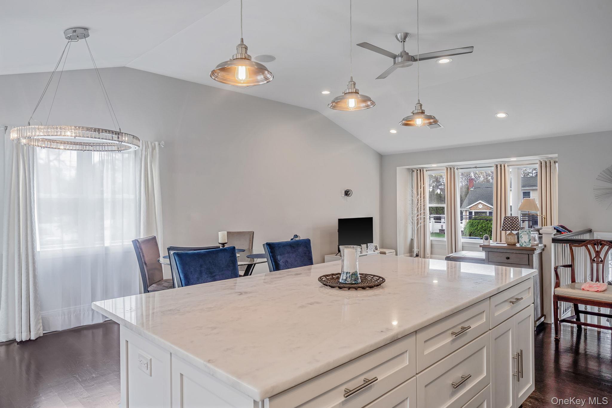 110 Stephen Road Bayport, NY 11705 - Photo 19 of 39 a view of a dining room and livingroom with furniture wooden floor a chandelier