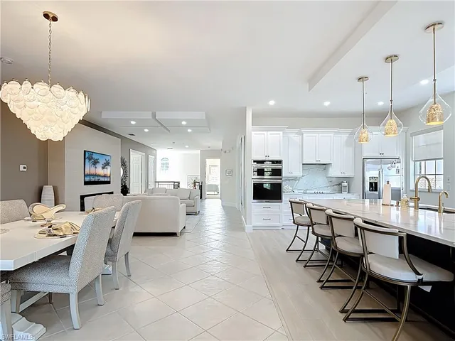 a large living room with stainless steel appliances kitchen island granite countertop a large window a couch and a view of living room