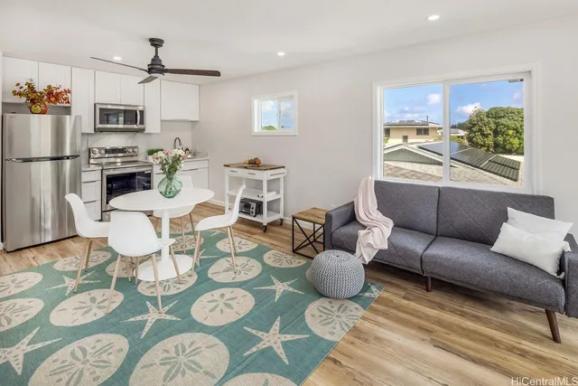 a living room with furniture and a dining table with kitchen view
