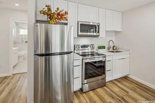 a kitchen with stainless steel appliances a stove a refrigerator and a microwave
