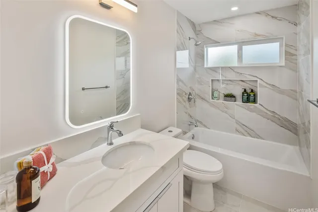 a bathroom with a granite countertop sink toilet and shower