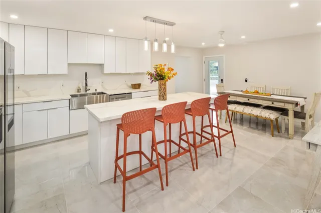 a kitchen with stainless steel appliances kitchen island granite countertop a table and chairs in it