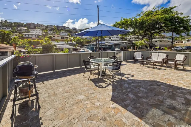 a view of a patio with chairs under an umbrella
