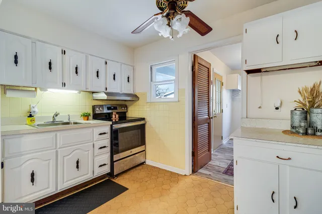 a kitchen with stainless steel appliances white cabinets and wooden floors