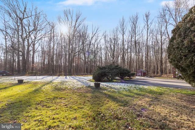 a view of a large house with a big yard and large trees
