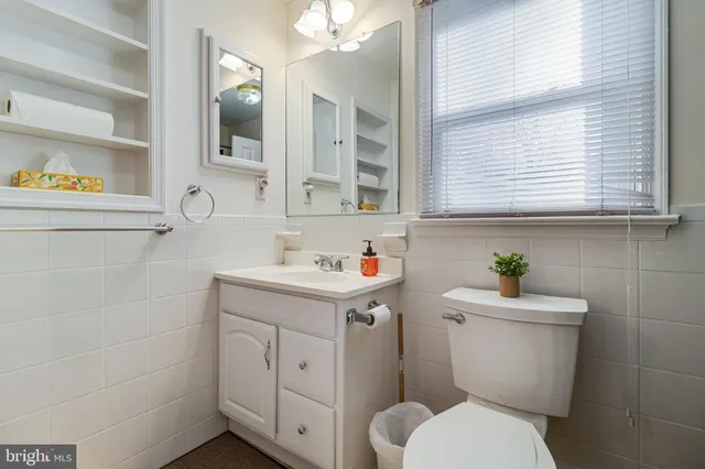 a bathroom with a sink a toilet and a window